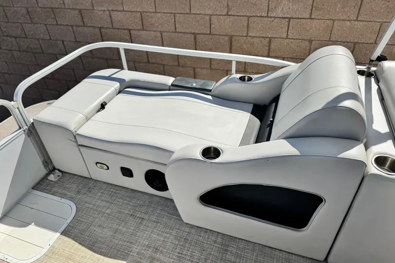 Slide: The Image of 2020 SunCatcher V24 SS boat interior with gray seating and cup holders. - 19