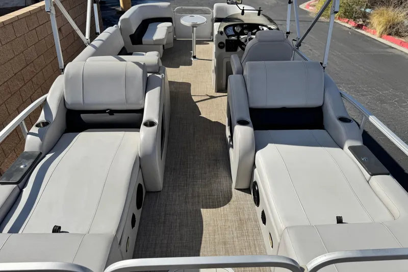 Slide: The Image of 2020 SunCatcher V24 SS pontoon boat interior with plush seating and steering console. - 22