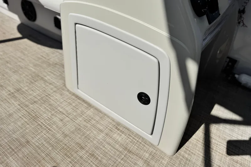 Slide: The Image of 2020 SunCatcher V24 SS boat storage compartment with lock on textured surface. - 25