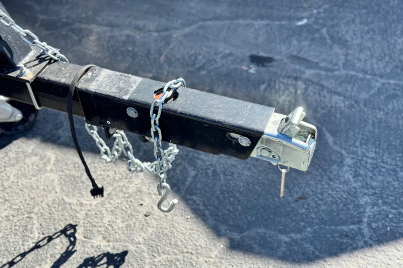Slide: The Image of Trailer hitch of a 2020 SunCatcher V24 SS with safety chains and lock mechanism. - 27