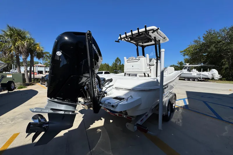 Slide: The Image of 2026 Caymas 26 HB boat with powerful outboard motor on a trailer, parked outdoors. - 11