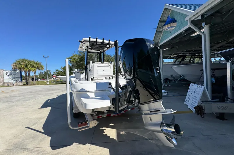 Slide: The Image of 2026 Caymas 26 HB boat with powerful outboard motor in a sunny marina setting. - 14