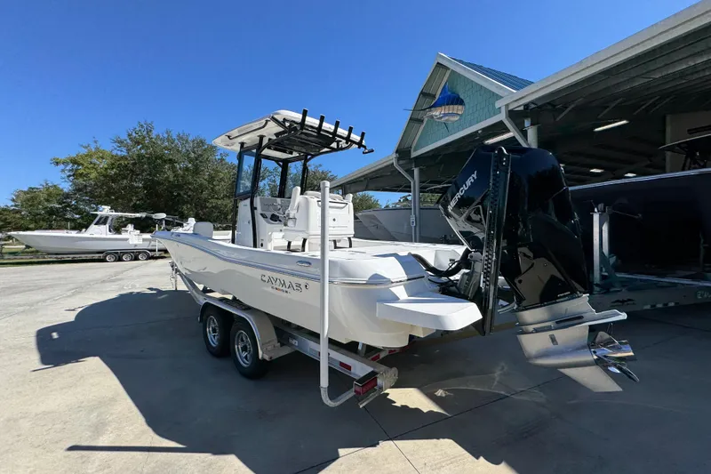 Slide: The Image of 2026 Caymas 26 HB boat on trailer, parked outdoors near a covered area. - 15