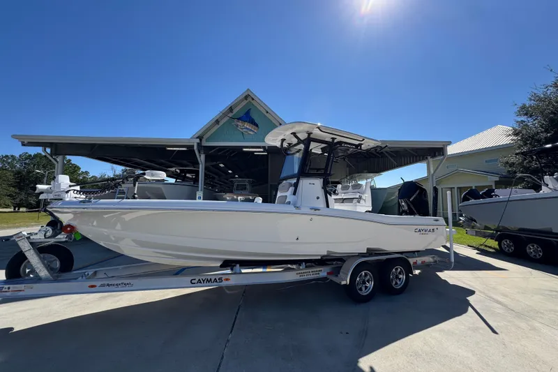 Slide: The Image of 2026 Caymas 26 HB boat on trailer, parked outdoors under clear blue sky. - 2