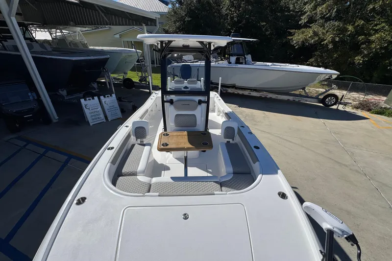 Slide: The Image of 2026 Caymas 26 HB boat with sleek design, docked outdoors under sunlight. - 20