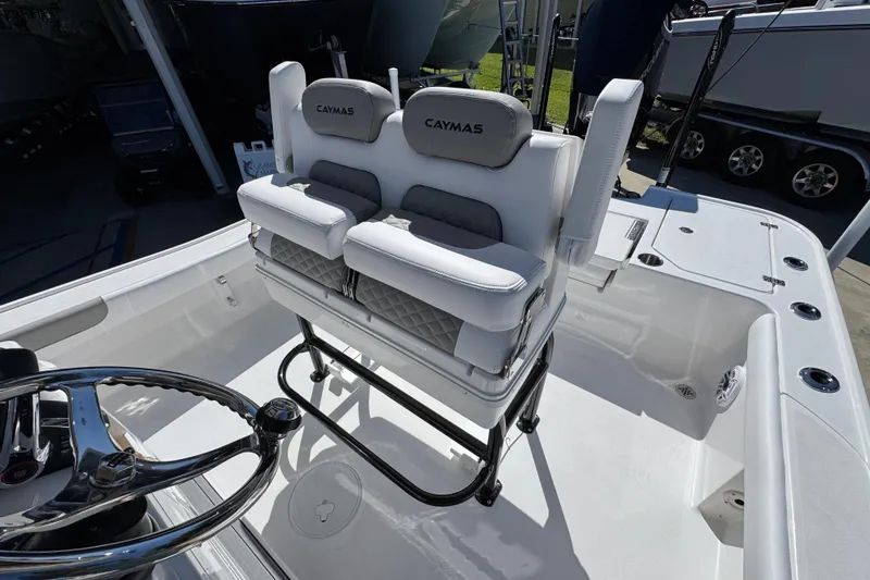 Slide: The Image of 2026 Caymas 26 HB boat interior with cushioned seating and steering wheel. - 24