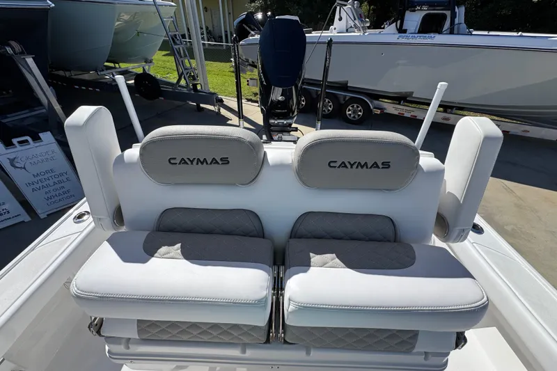 Slide: The Image of 2026 Caymas 26 HB boat seating with logo, displayed at a marine dealership. - 25