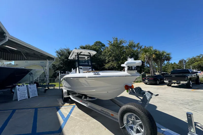 Slide: The Image of 2026 Caymas 26 HB boat on trailer, parked outdoors under clear blue sky. - 6