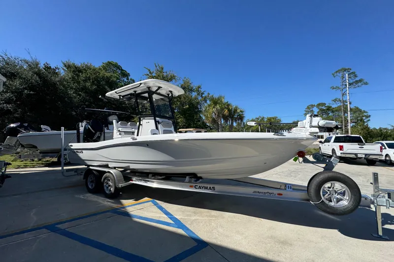 Slide: The Image of 2026 Caymas 26 HB boat on trailer, parked outdoors under clear blue sky. - 7