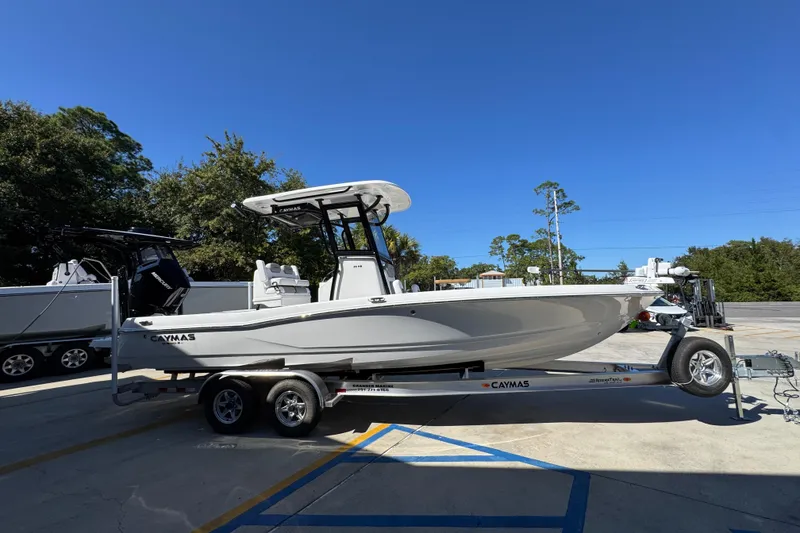 Slide: The Image of 2026 Caymas 26 HB boat on trailer, parked outdoors under clear blue sky. - 8