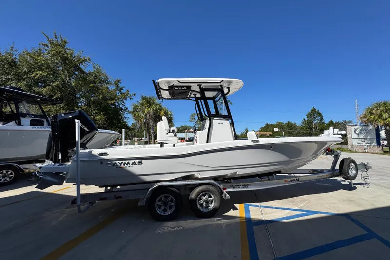 Slide: The Image of 2026 Caymas 26 HB boat on trailer, parked outdoors under clear blue sky. - 9