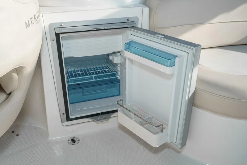 Slide: The Image of Open mini fridge on 2011 Meridian 341 Sedan boat, showcasing interior storage space. - 15