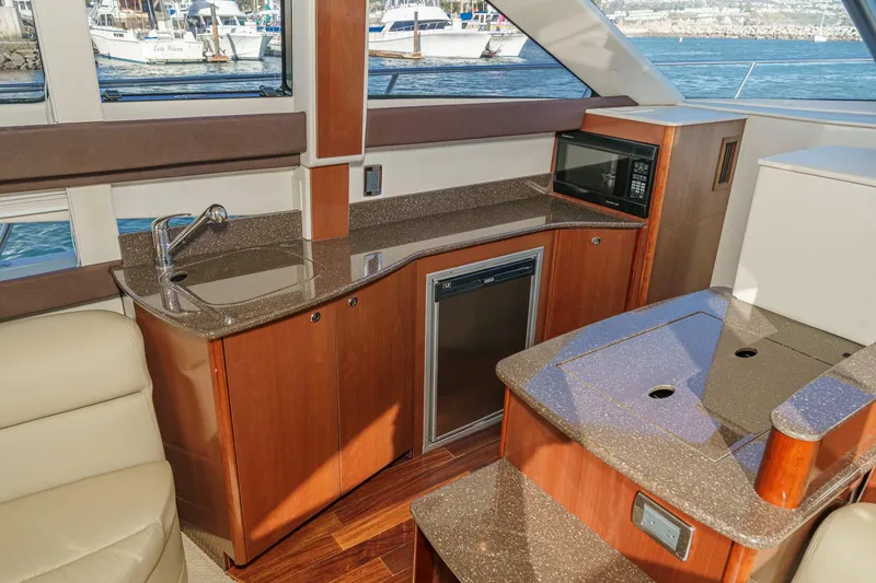 Slide: The Image of 2011 Meridian 341 Sedan yacht interior with kitchenette, featuring sink, microwave, and mini-fridge. - 27