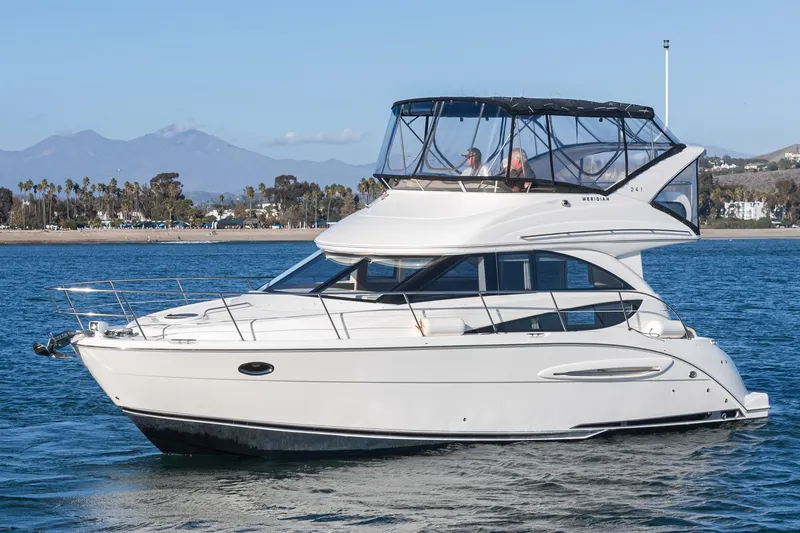 Slide: The Image of 2011 Meridian 341 Sedan yacht cruising on a scenic waterway with mountains in the background. - 42