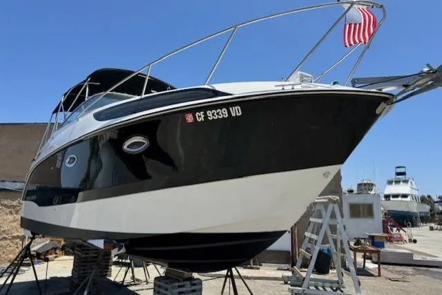 Slide: The Image of 2010 Bayliner 255 Cruiser boat on dry dock with American flag, sunny day. - 13