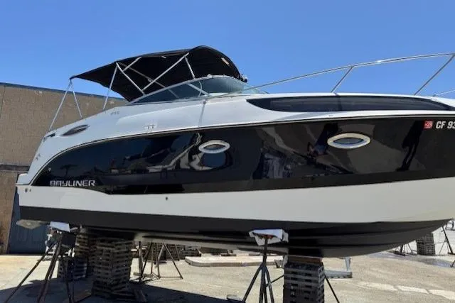 Slide: The Image of 2010 Bayliner 255 Cruiser boat on stands, black and white exterior, outdoor setting. - 14