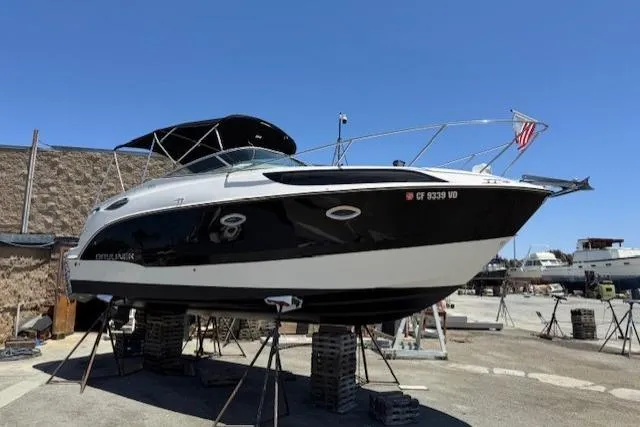 Slide: The Image of 2010 Bayliner 255 Cruiser boat on stands, black and white hull, outdoor setting. - 16