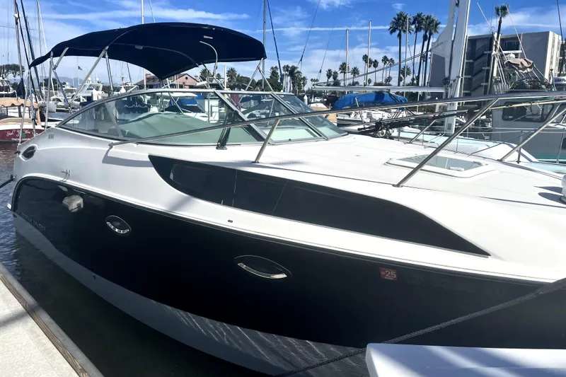Slide: The Image of 2010 Bayliner 255 Cruiser docked at marina under clear blue sky. - 2