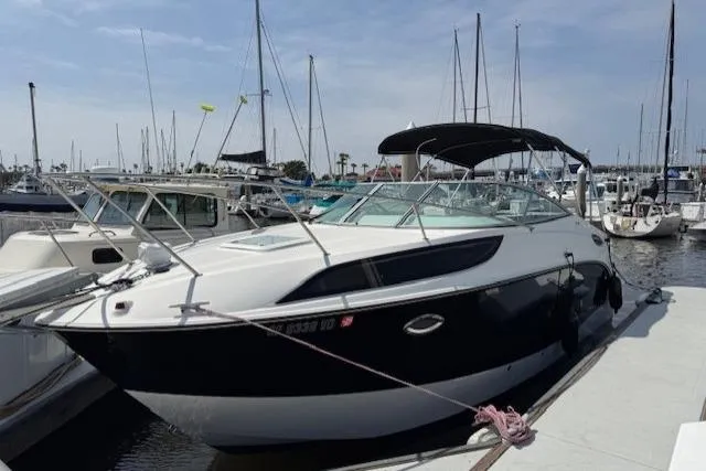 Slide: The Image of 2010 Bayliner 255 Cruiser docked at marina with sailboats in background. - 24