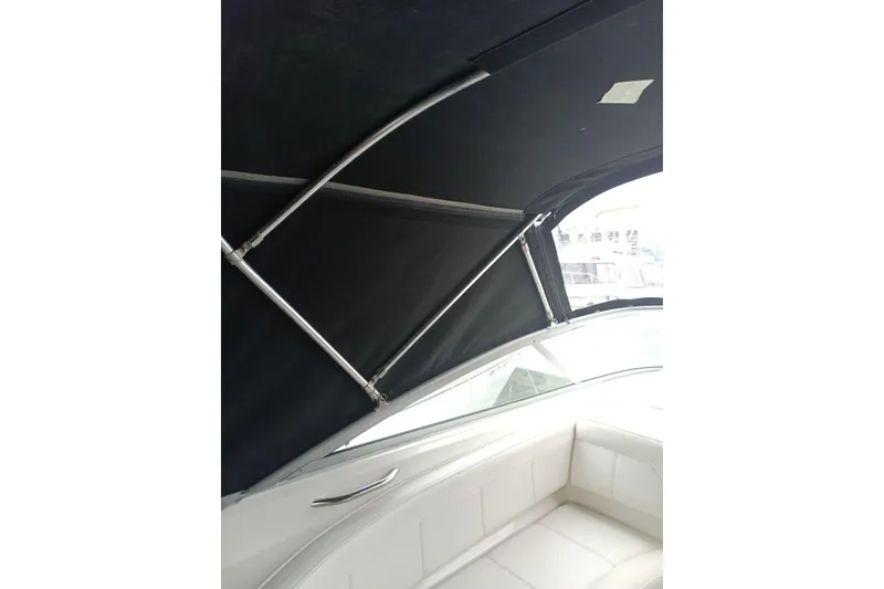 Slide: The Image of 2010 Bayliner 255 Cruiser interior with black canopy and white seating. - 28