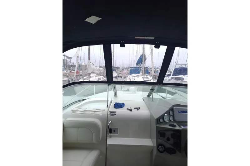 Slide: The Image of Interior view of 2010 Bayliner 255 Cruiser boat cockpit with marina background. - 30