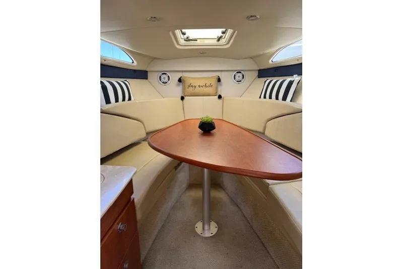 Slide: The Image of Interior of 2010 Bayliner 255 Cruiser with cozy seating and wooden table. - 38
