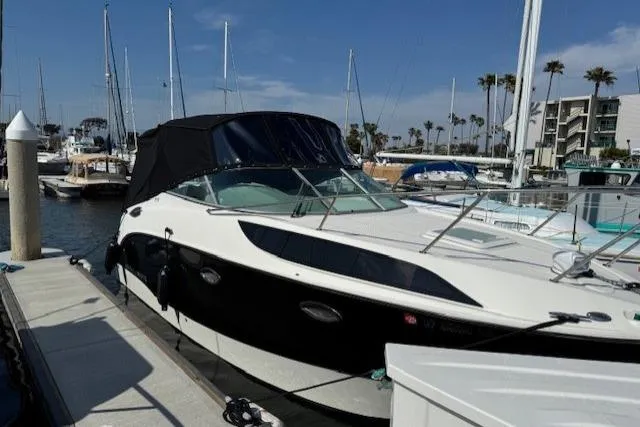 Slide: The Image of 2010 Bayliner 255 Cruiser docked at marina with sailboats in background. - 39