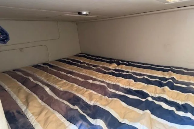 Slide: The Image of Interior cabin of 2010 Bayliner 255 Cruiser with striped bedding. - 40