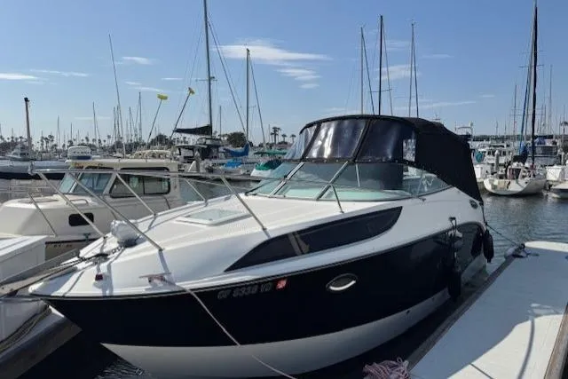 Slide: The Image of 2010 Bayliner 255 Cruiser docked at marina with sailboats in background. - 41