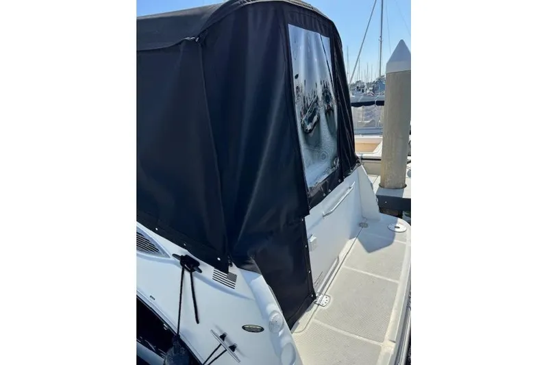 Slide: The Image of 2010 Bayliner 255 Cruiser with black canvas cover at marina dock. - 43