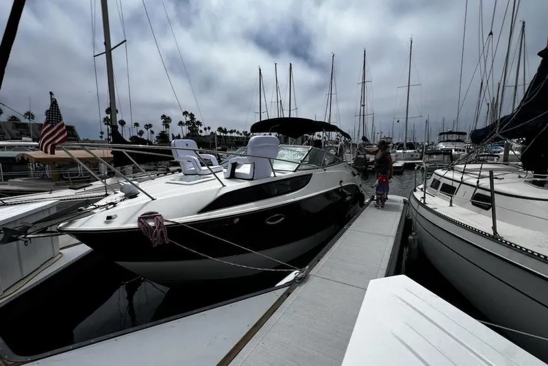 Slide: The Image of 2010 Bayliner 255 Cruiser docked at marina with American flag. - 44