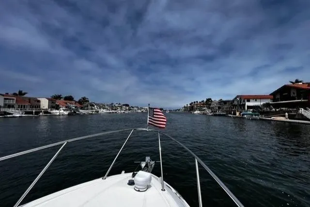 Slide: The Image of Bayliner 255 Cruiser 2010 navigating a scenic waterway with American flag. - 48