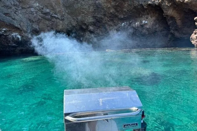 Slide: The Image of Bayliner 255 Cruiser 2010 near rocky shore with clear turquoise water and a smoking grill. - 52