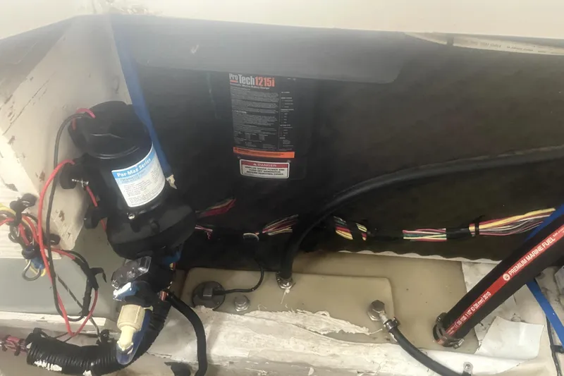 Slide: The Image of 2010 Bayliner 255 Cruiser engine compartment with wiring and fuel lines. - 56