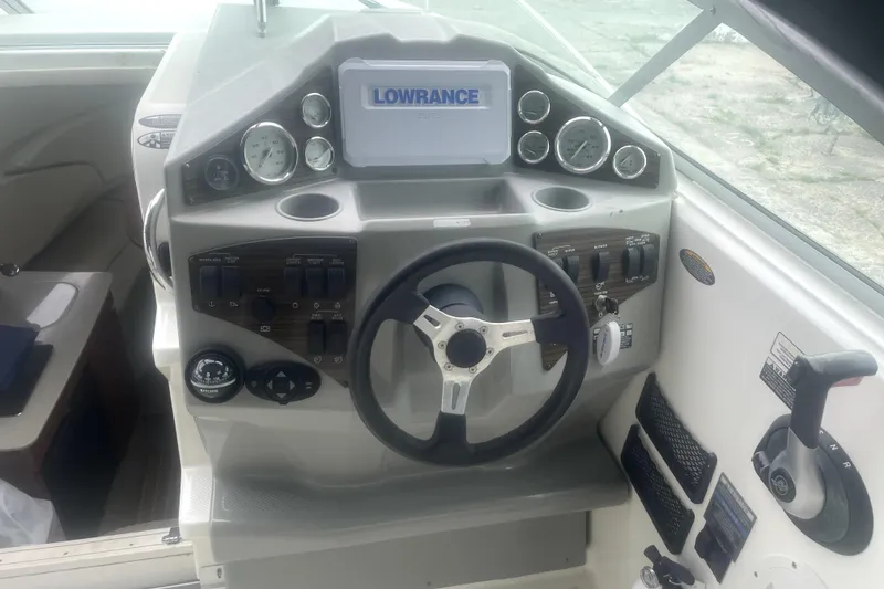 Slide: The Image of 2010 Bayliner 255 Cruiser dashboard with steering wheel and navigation controls. - 58
