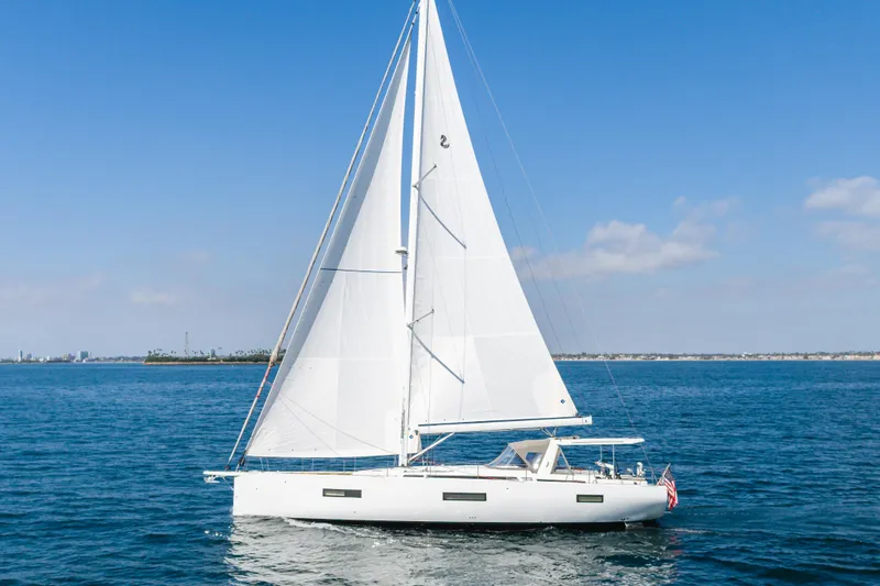 Slide: The Image of 2023 Beneteau Oceanis Yacht 60 sailing on open water under clear blue skies. - 10