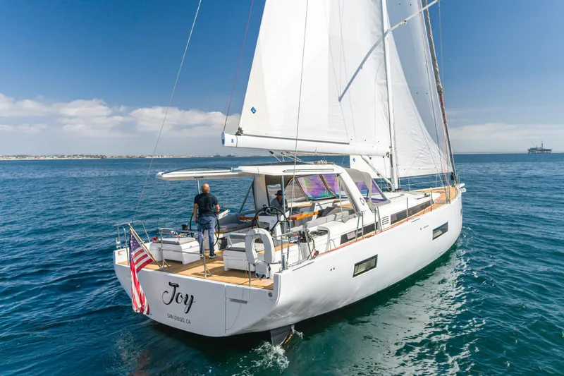 Slide: The Image of 2023 Beneteau Oceanis Yacht 60 sailing on open water, featuring sleek design and spacious deck. - 13