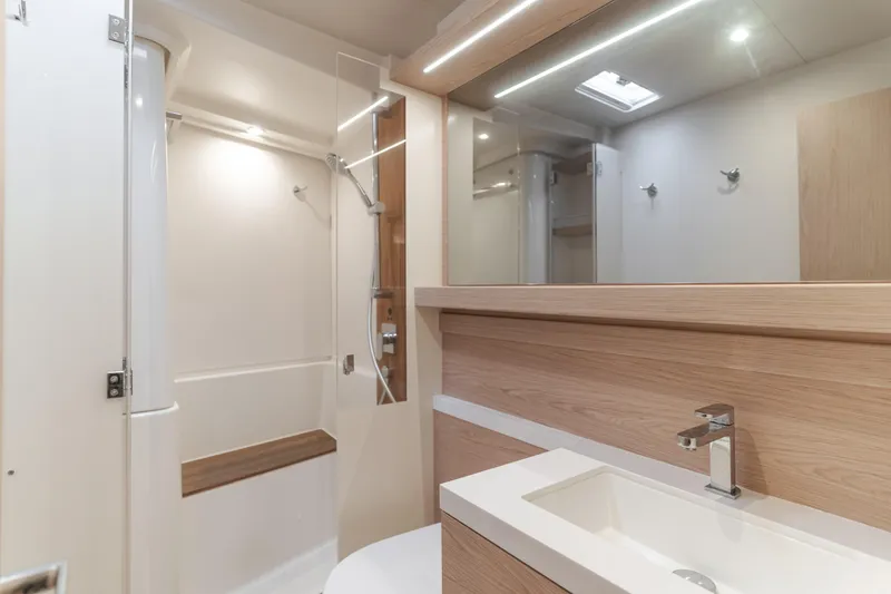 Slide: The Image of Modern bathroom interior of 2023 Beneteau Oceanis Yacht 60, featuring sleek fixtures and wood accents. - 39