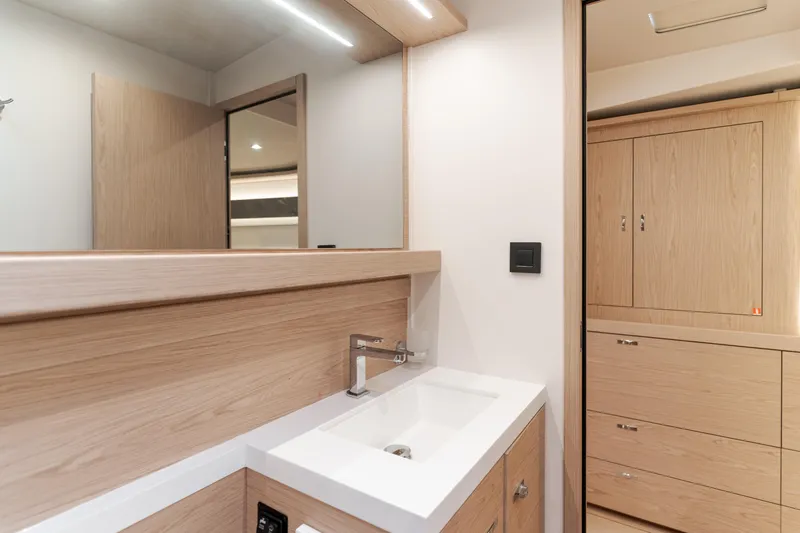 Slide: The Image of Modern bathroom interior on 2023 Beneteau Oceanis Yacht 60, featuring sleek wood cabinetry and minimalist design. - 40