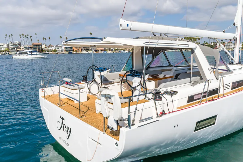 Slide: The Image of 2023 Beneteau Oceanis Yacht 60 sailing in a scenic harbor, showcasing elegant design. - 6