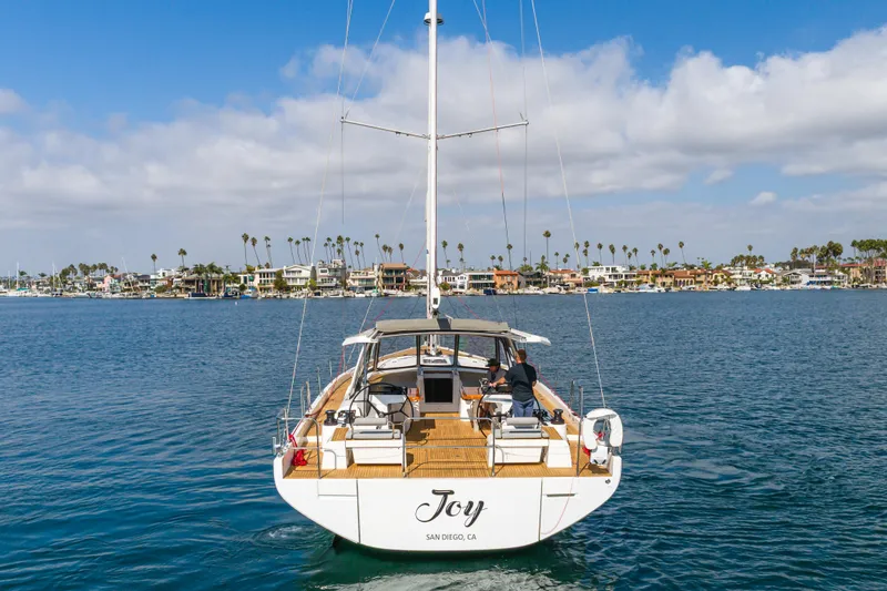 Slide: The Image of 2023 Beneteau Oceanis Yacht 60 sailing in San Diego harbor, clear skies, coastal homes. - 7