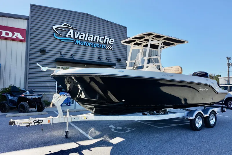 The Image of 2026 Bayliner Trophy T22CC boat on trailer at Avalanche Motorsports dealership. - 1