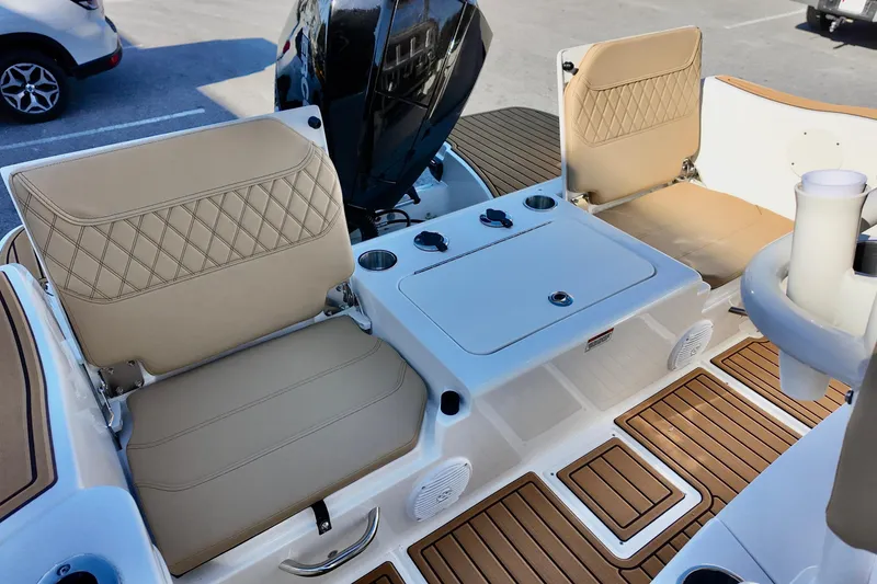 Slide: The Image of 2026 Bayliner Trophy T22CC boat interior with beige seating and wood-style flooring. - 10