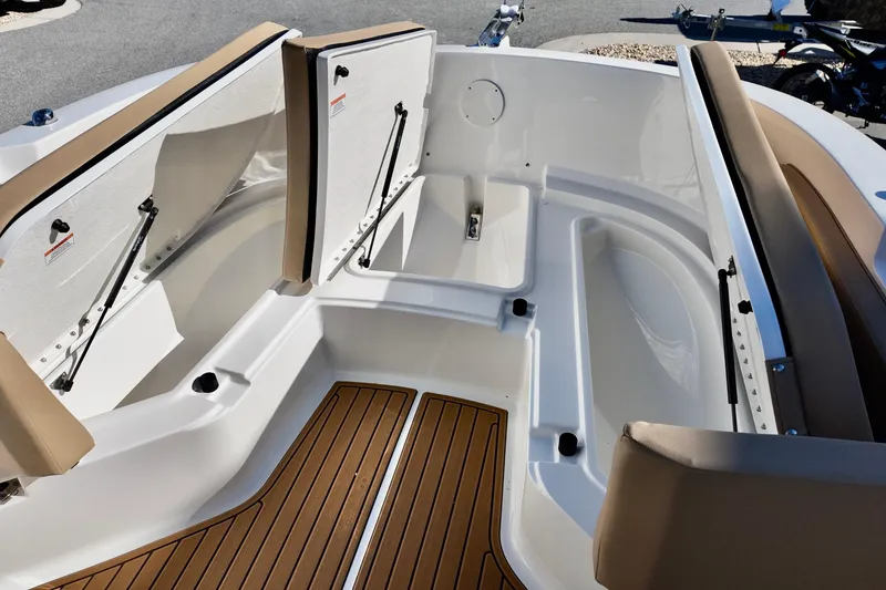Slide: The Image of 2026 Bayliner Trophy T22CC boat interior with open storage compartments and cushioned seating. - 15
