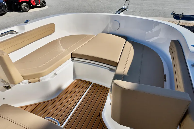 Slide: The Image of 2026 Bayliner Trophy T22CC boat interior with beige seating and wooden flooring. - 16
