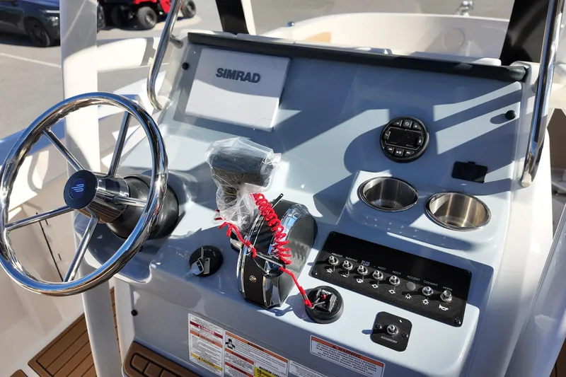 Slide: The Image of 2026 Bayliner Trophy T22CC boat dashboard with steering wheel and controls. - 9