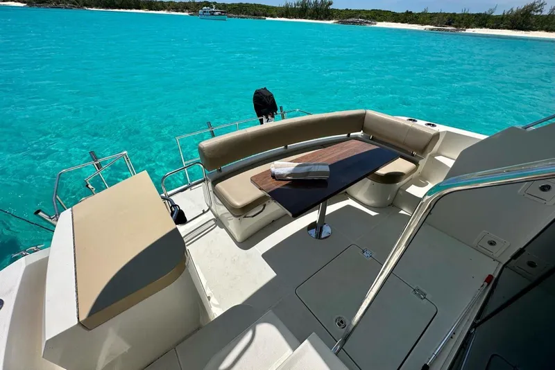Slide: The Image of Luxurious 2017 Carver C40 yacht deck with seating, table, and stunning turquoise water view. - 12