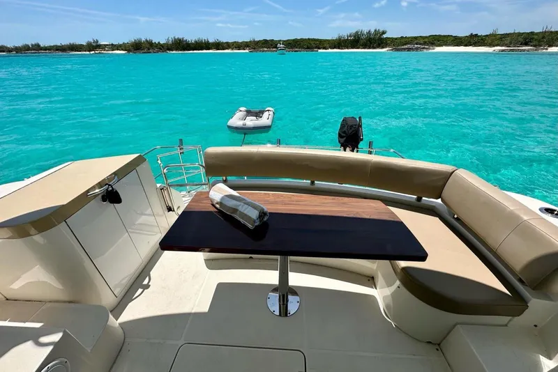 Slide: The Image of Luxurious 2017 Carver C40 yacht with elegant seating, table, and stunning turquoise water view. - 13
