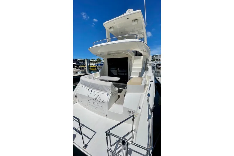 Slide: The Image of 2017 Carver C40 yacht docked, featuring spacious deck and elegant design under clear blue sky. - 3