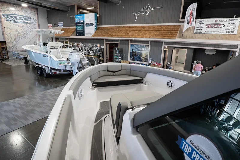 Slide: The Image of Showroom display of a 2026 Monterey Elite 25 OB boat with luxurious seating. - 11